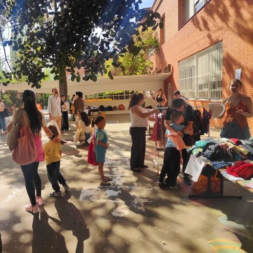 Personas en el patio participando en el mercadillo del colegio