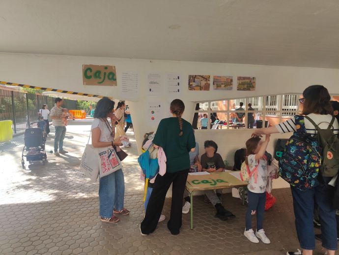 Personas asistiendo al mercadillo de ropa en el colegio